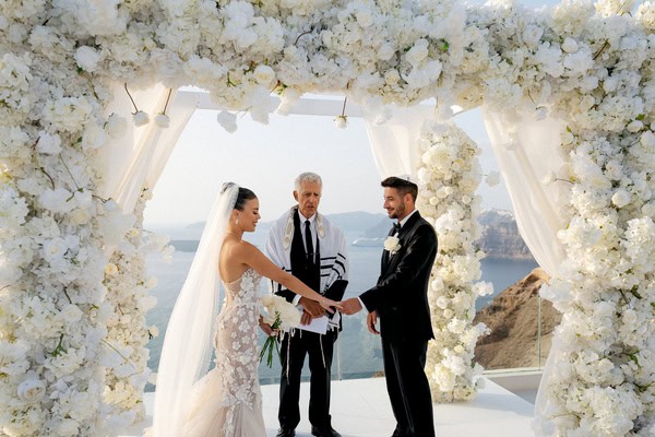 Romantic destination wedding in Santorini with a breathtaking floral arch | Macy & Will